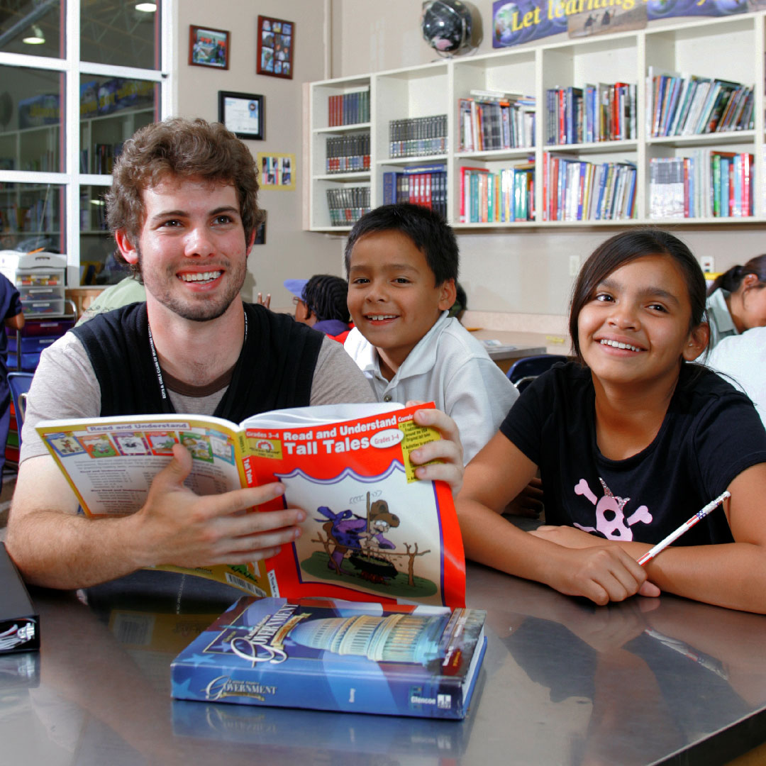CSUMB student reading to children at the Boys and Girls Club