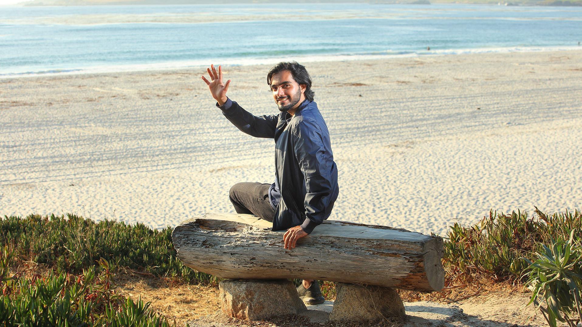 Photo: A student waving on the beach