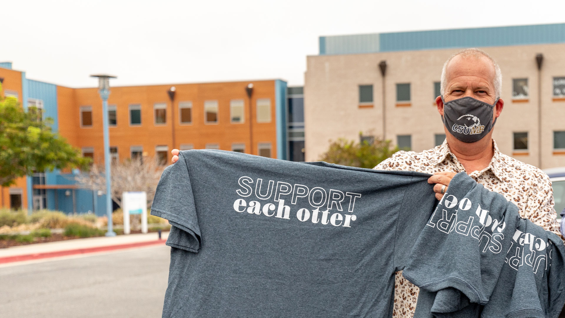 Photo: Staff holding up Support Each Otter T-shirts