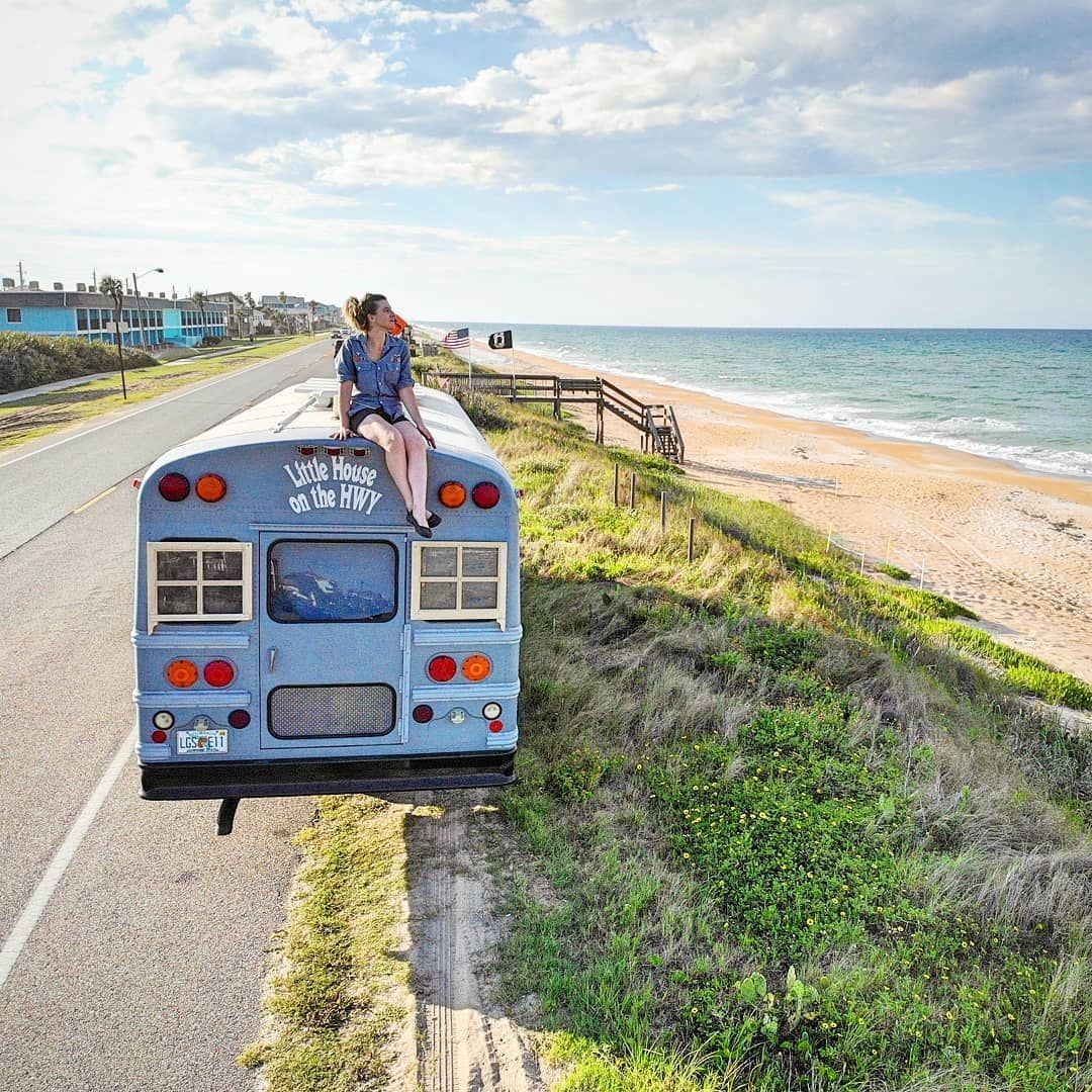 Elizabeth Hensley sits atop the converted gray school bus that is her home.