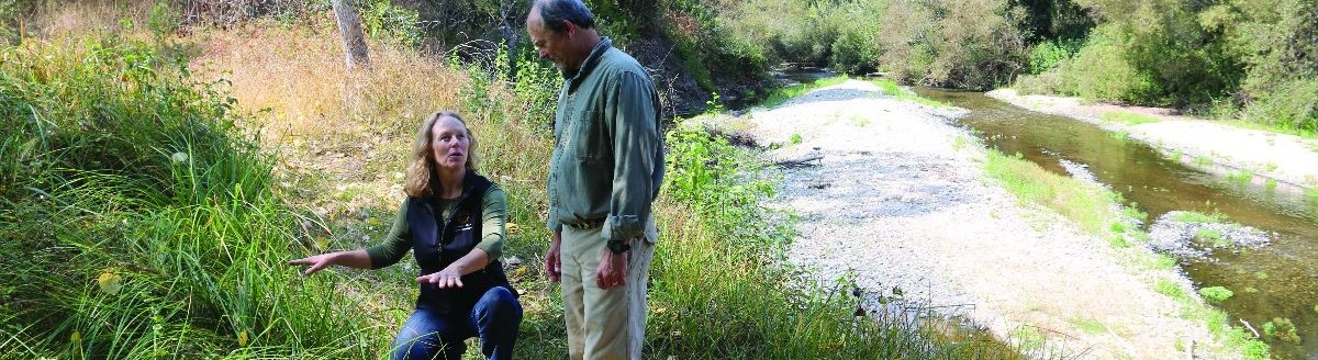 two people on the bank of a river