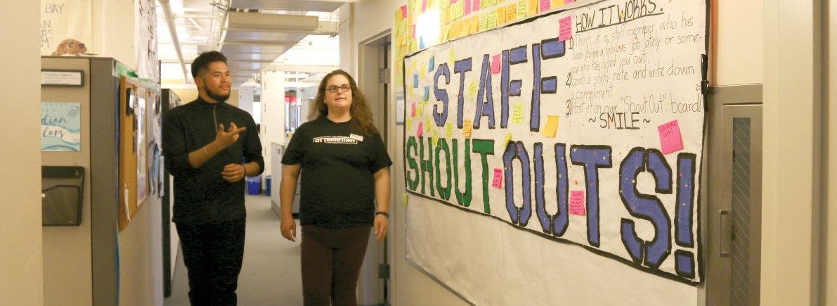 students standing in an office hallway.