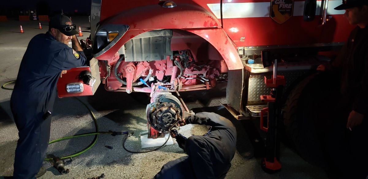 Mechanics working on a fire engine truck .