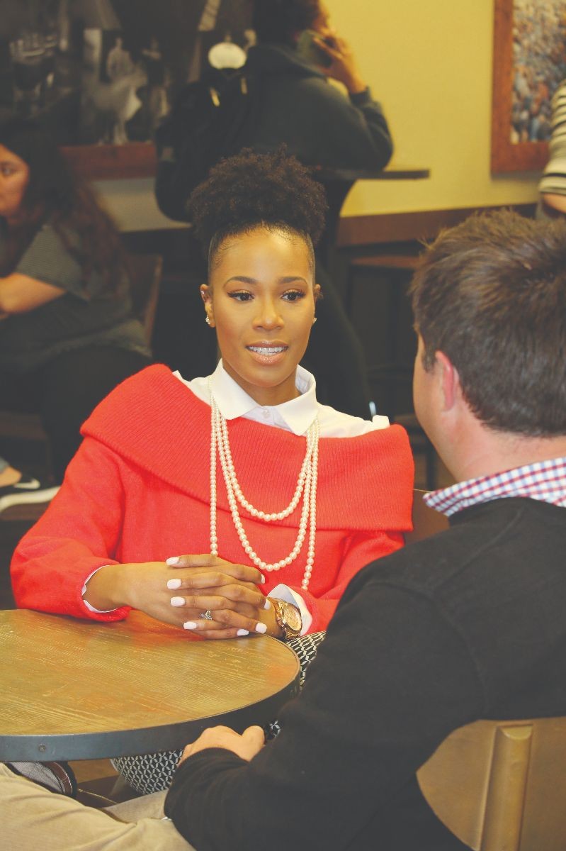 Jones talking to a co-worker in a cafe.