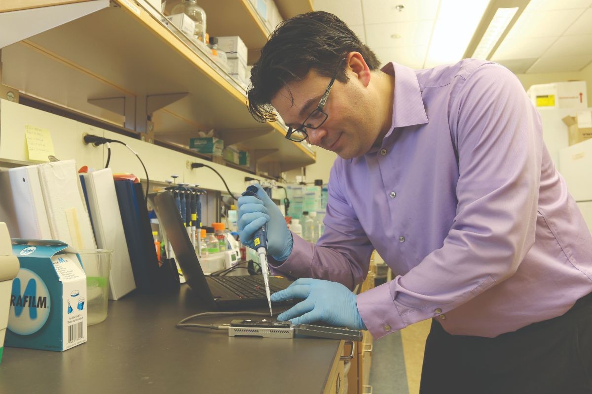 Nate Jue in his lab working with hardware