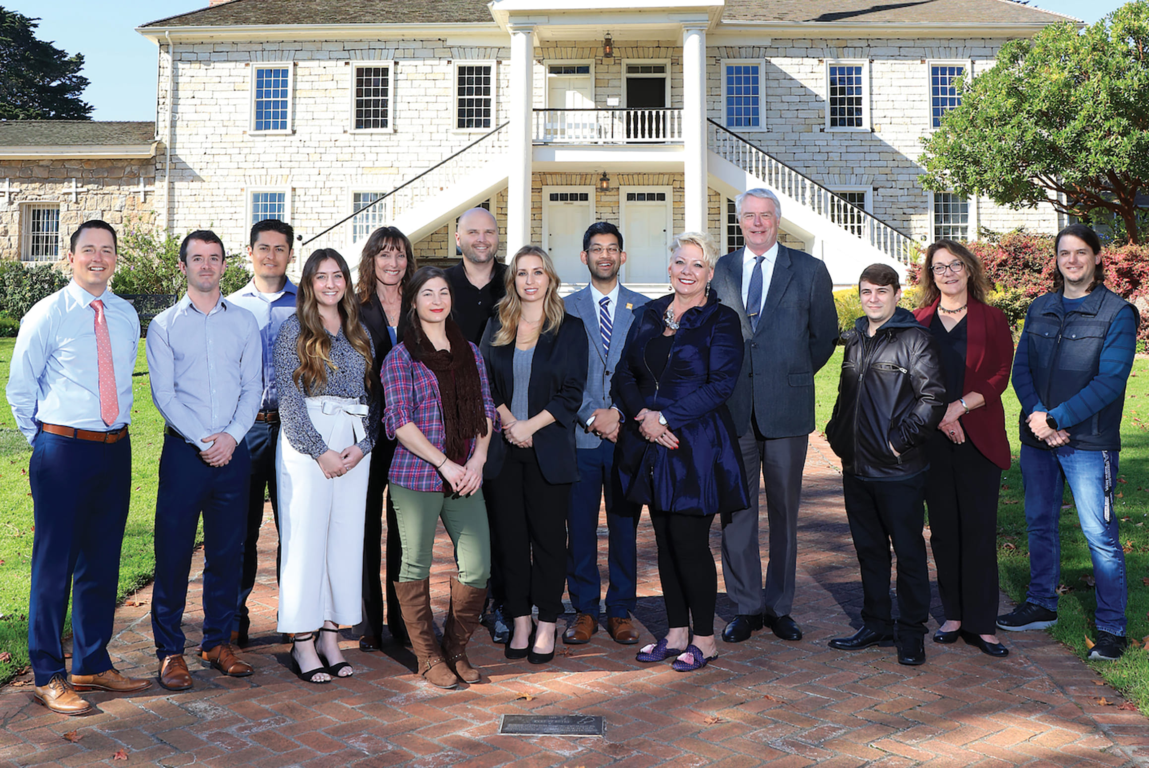 CSUMB alumni who are city of Monterey employees outside Colton Hall Museum with City Manager Hans Uslar (fourth from right). From left: Jay Punkar, Eric Palmer, Rafael Albarran, Kristonee Wade, Gundy Rettke, Jennifer Cleary, Ben Fowler, Paige Smith, Nat Rojanasathira, Wendy Davies, (Uslar), Vince Pizzo, Olga Maximoff and Jordan Leininger.