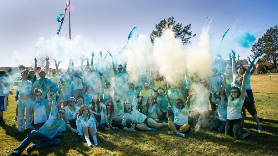 Students throwing Diwali color chalk in the air