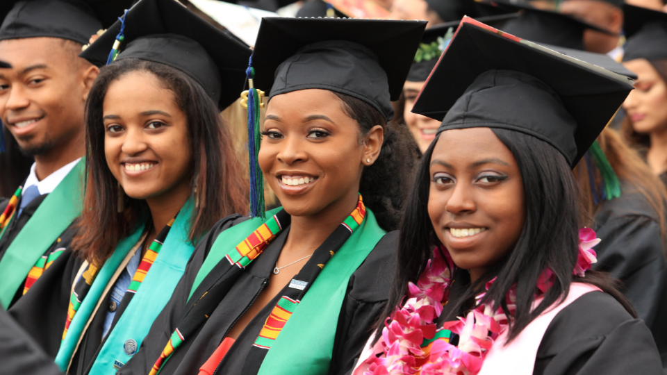 Students sitting at graduation and smiling