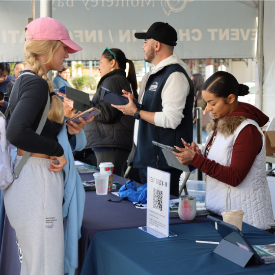 Student at the event check-in tent being helped by an Admissions staff member