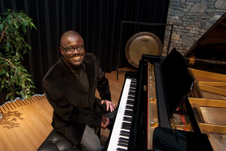 John Wineglass sits at piano