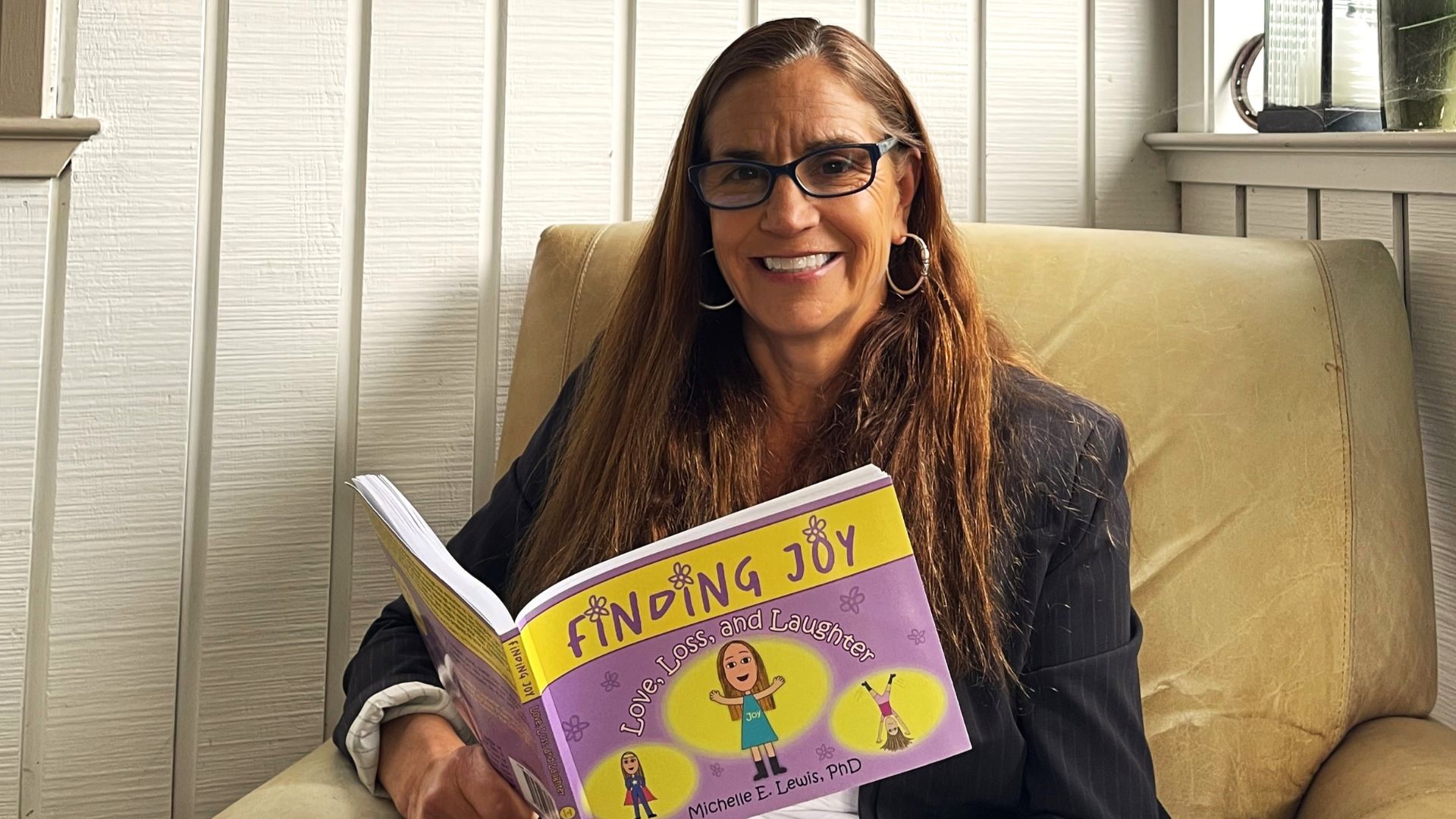 Michelle Lewis flips through her book Finding Joy