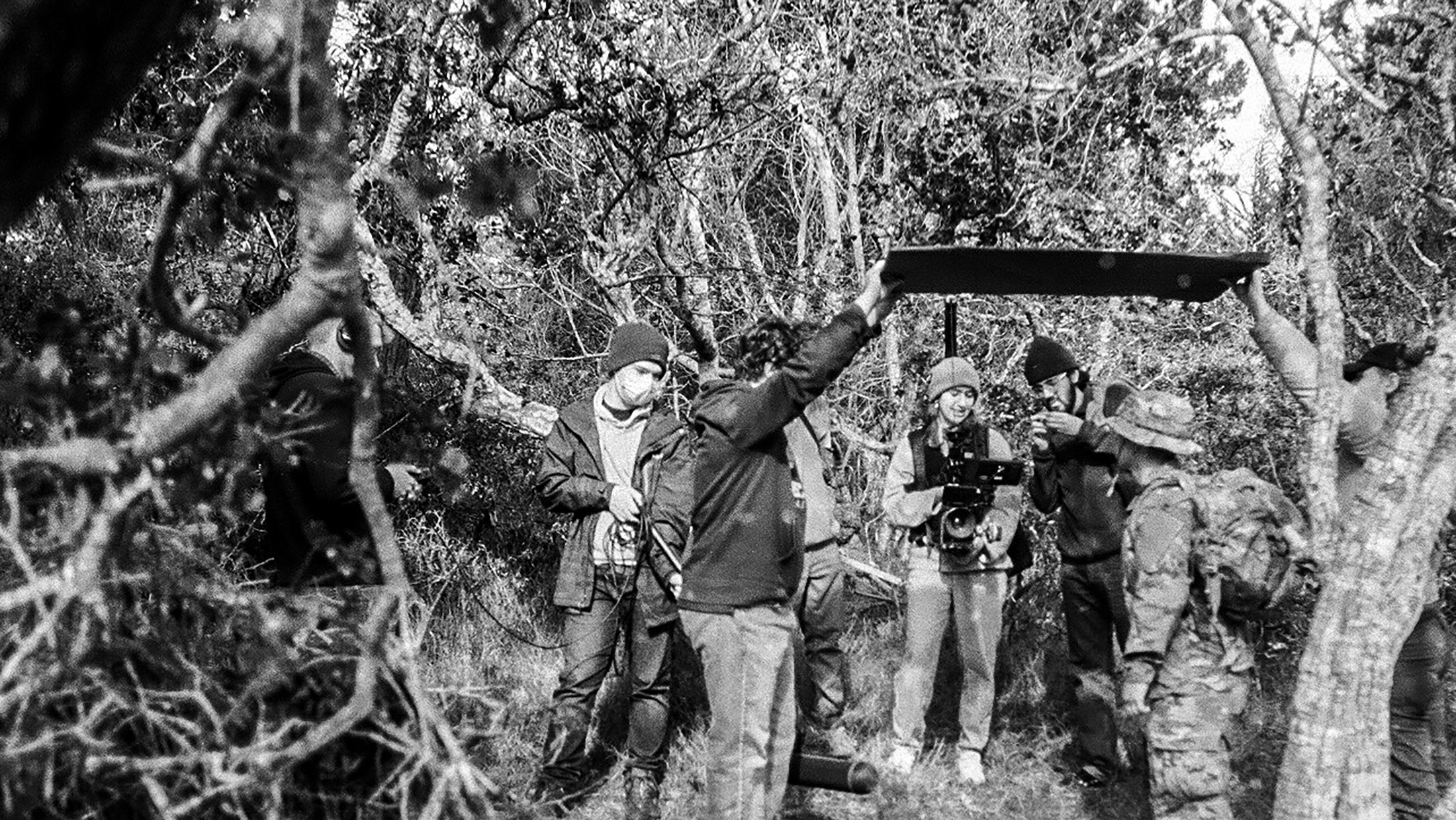 group of students in the woods filming