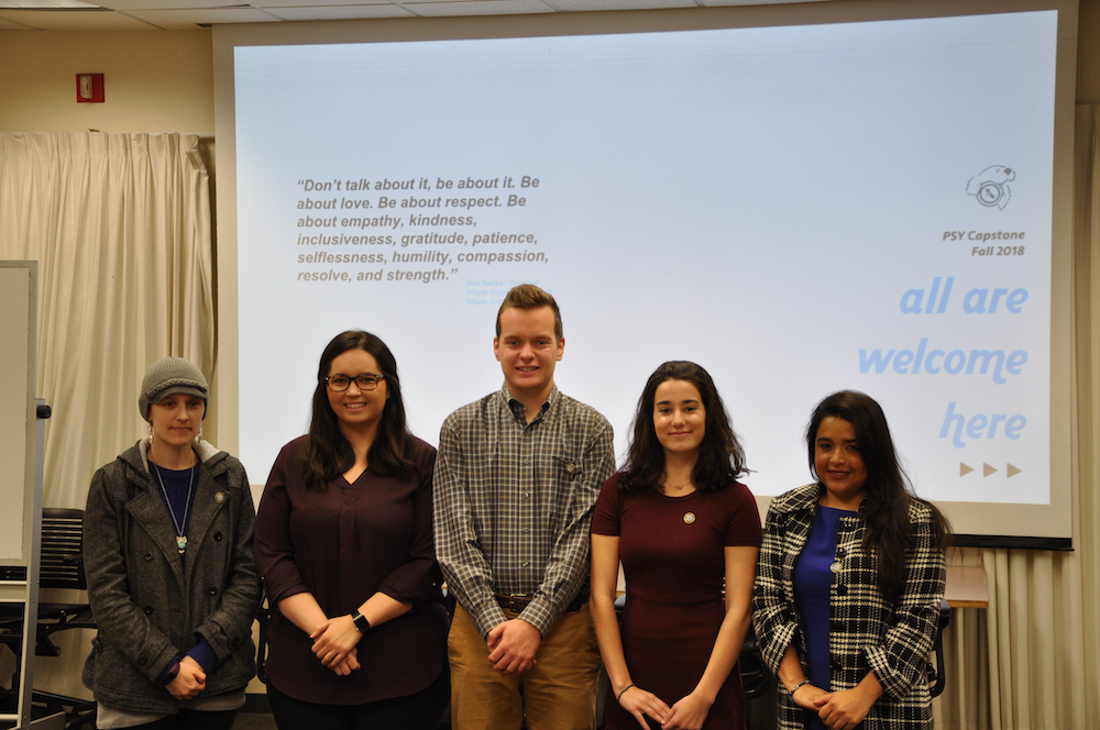 Students posing in front of a powerpoint.