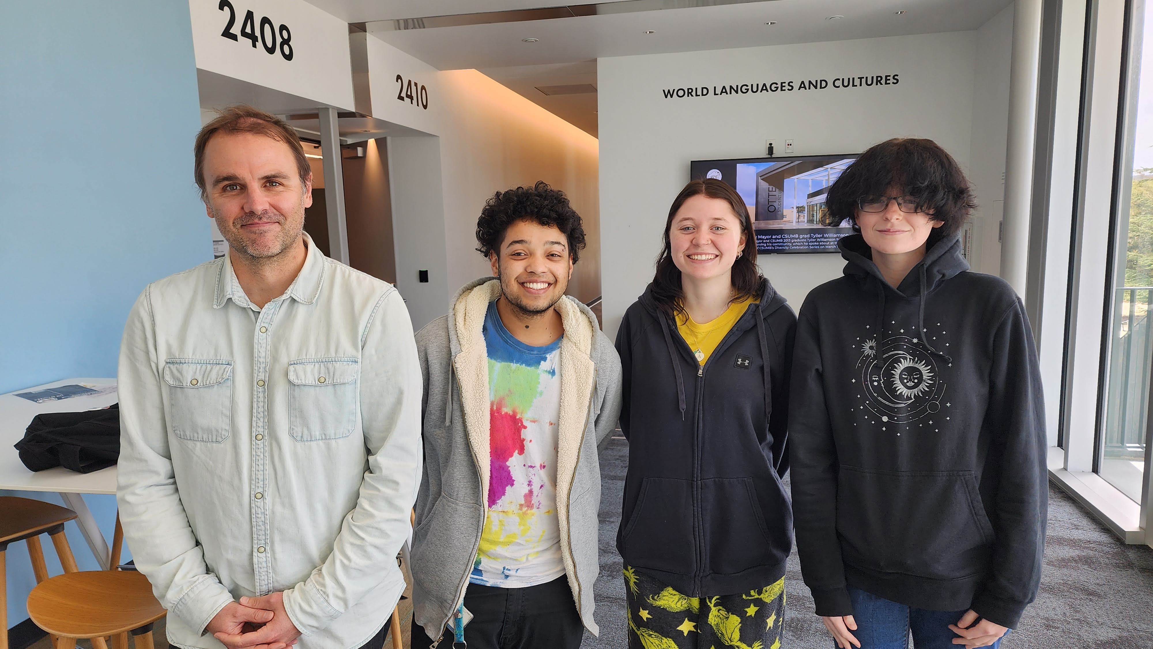 Students and faculty pose outside lobby to Department of World Languages and Cultures