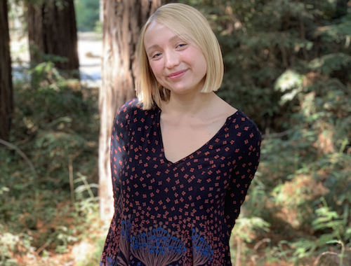 Woman wearing dress standing in forest glade