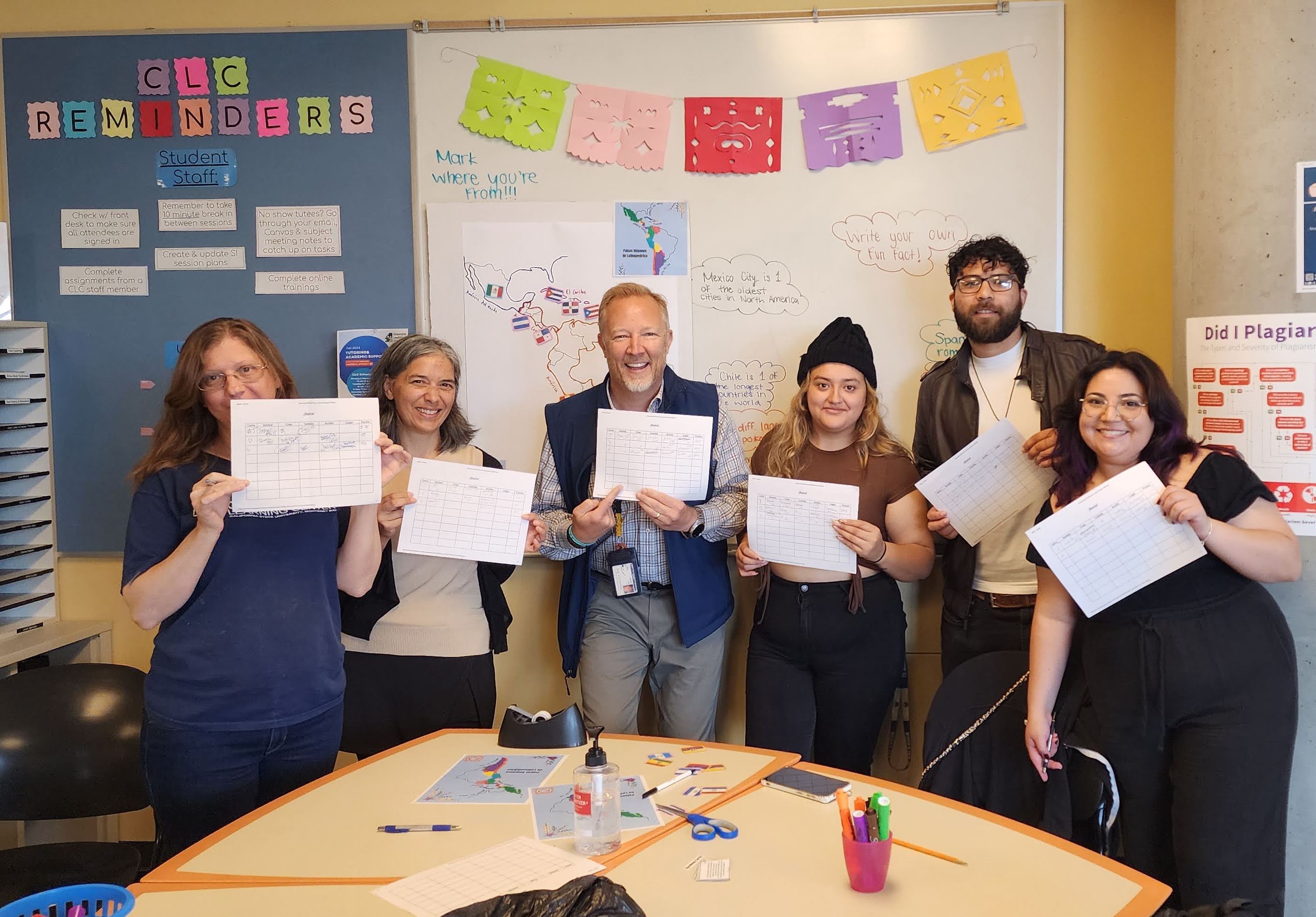 Participants from Spanish Club, Faculty and Staff display their score cards after playing rounds of Basta