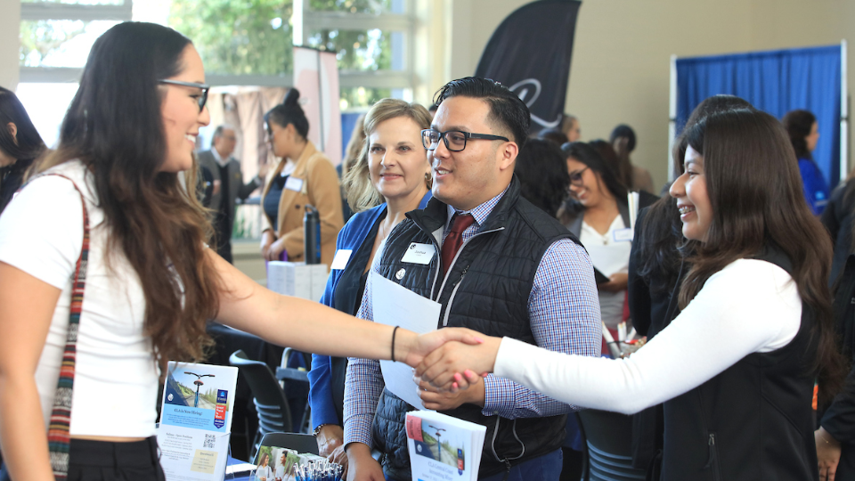 CSUMB Alum, Cristal Perez Paz, Tax Associate with CLA (CliftonLarsonAllen), greets student at 2023 ANE