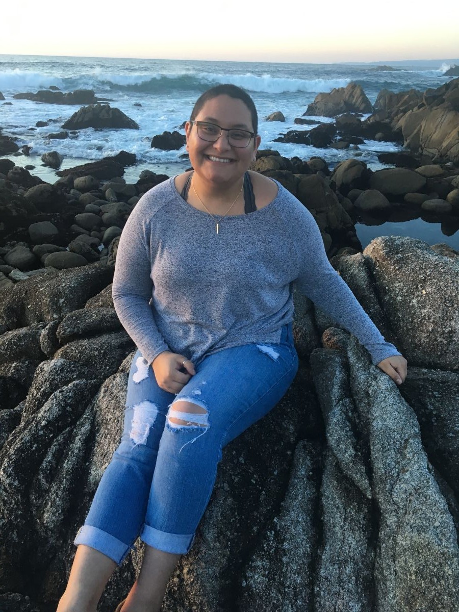 Kristi sitting on a rock on the beach