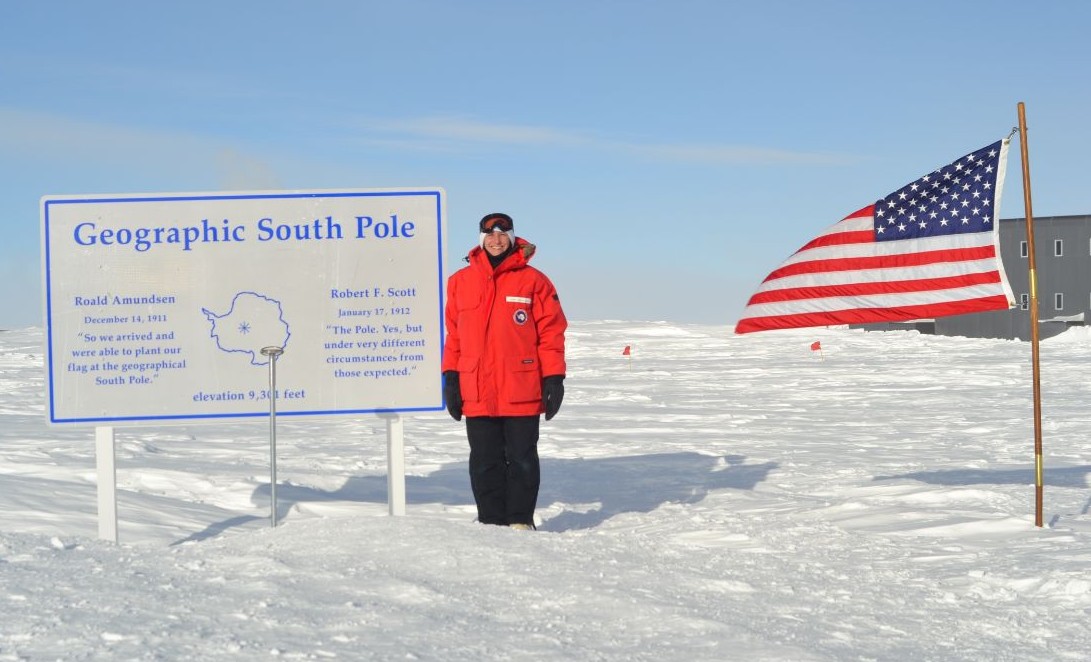 Cherisa smiling and standing next to a map and sign that says 