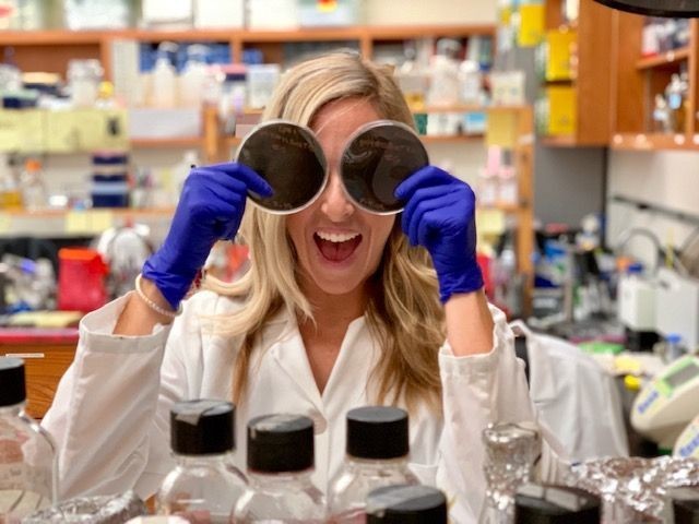 Student holding up petri dishes