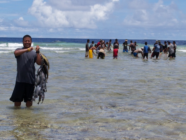 Ulithi fishermen gathering fish from a net