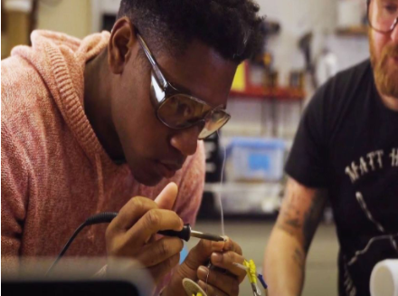 graduate student soldering electronics