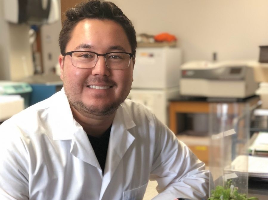 A male student smiling in a lab