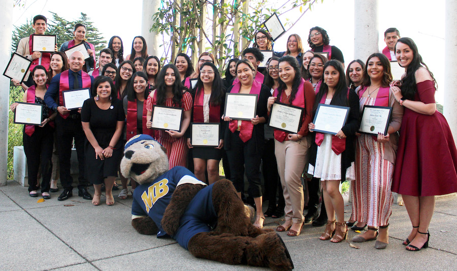 TRIO Graduates from 2019 at Senior Celebration with Monte, holding certificates and wearing TRIO stoles