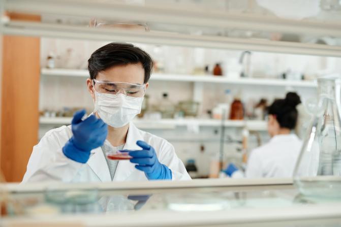 Student collecting sample from petri dish