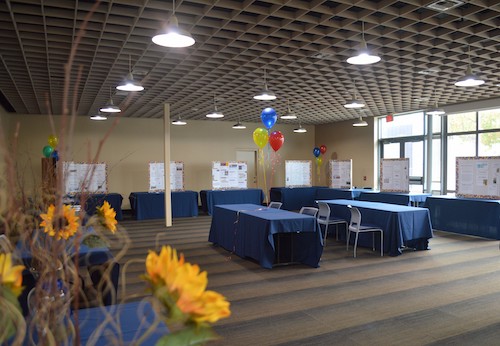 Vista set up with long tables all around the room for displaying