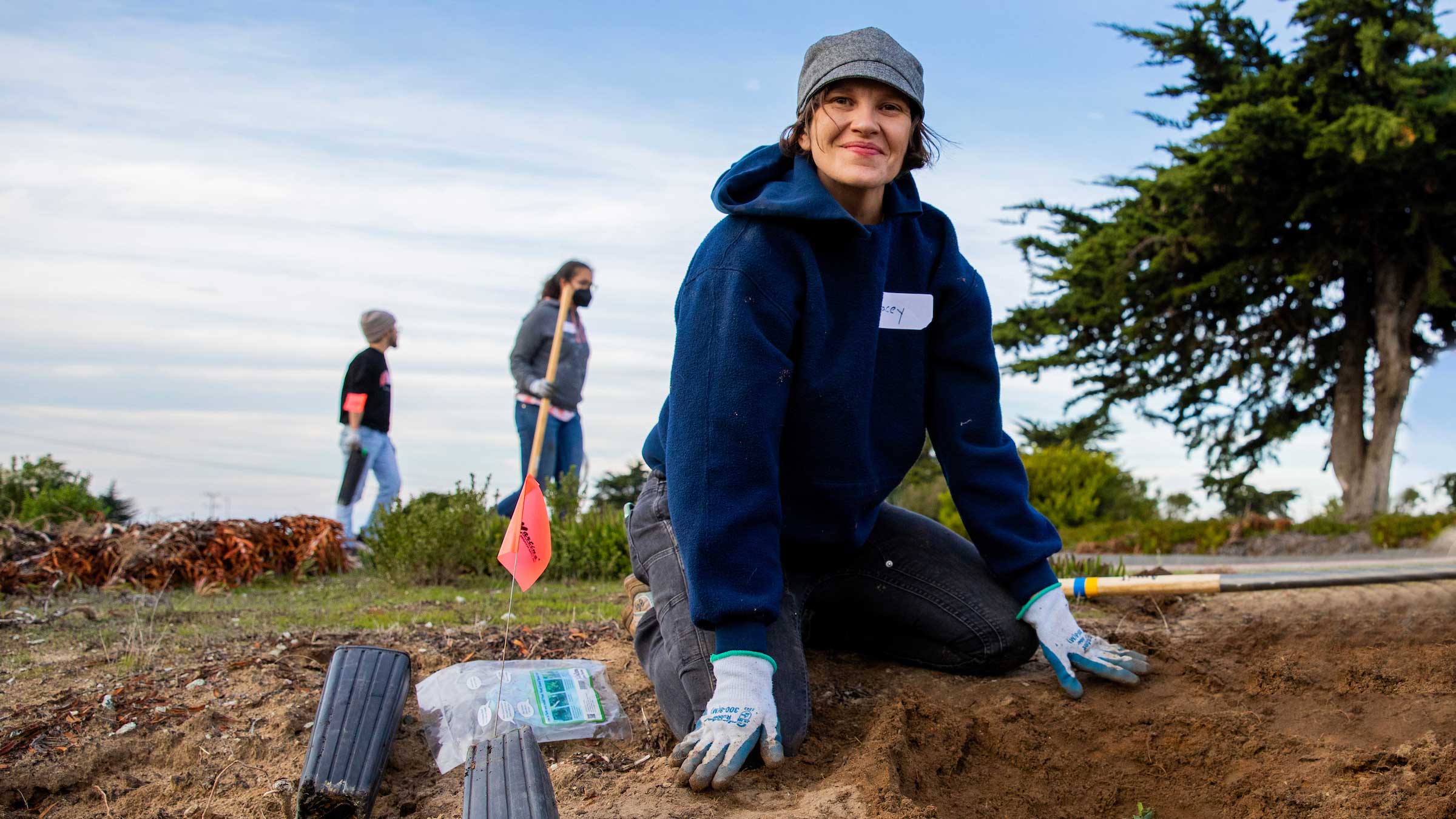 Lacey Raak planting coast live oak trees during the Habitat Restoration and Tree Planting event