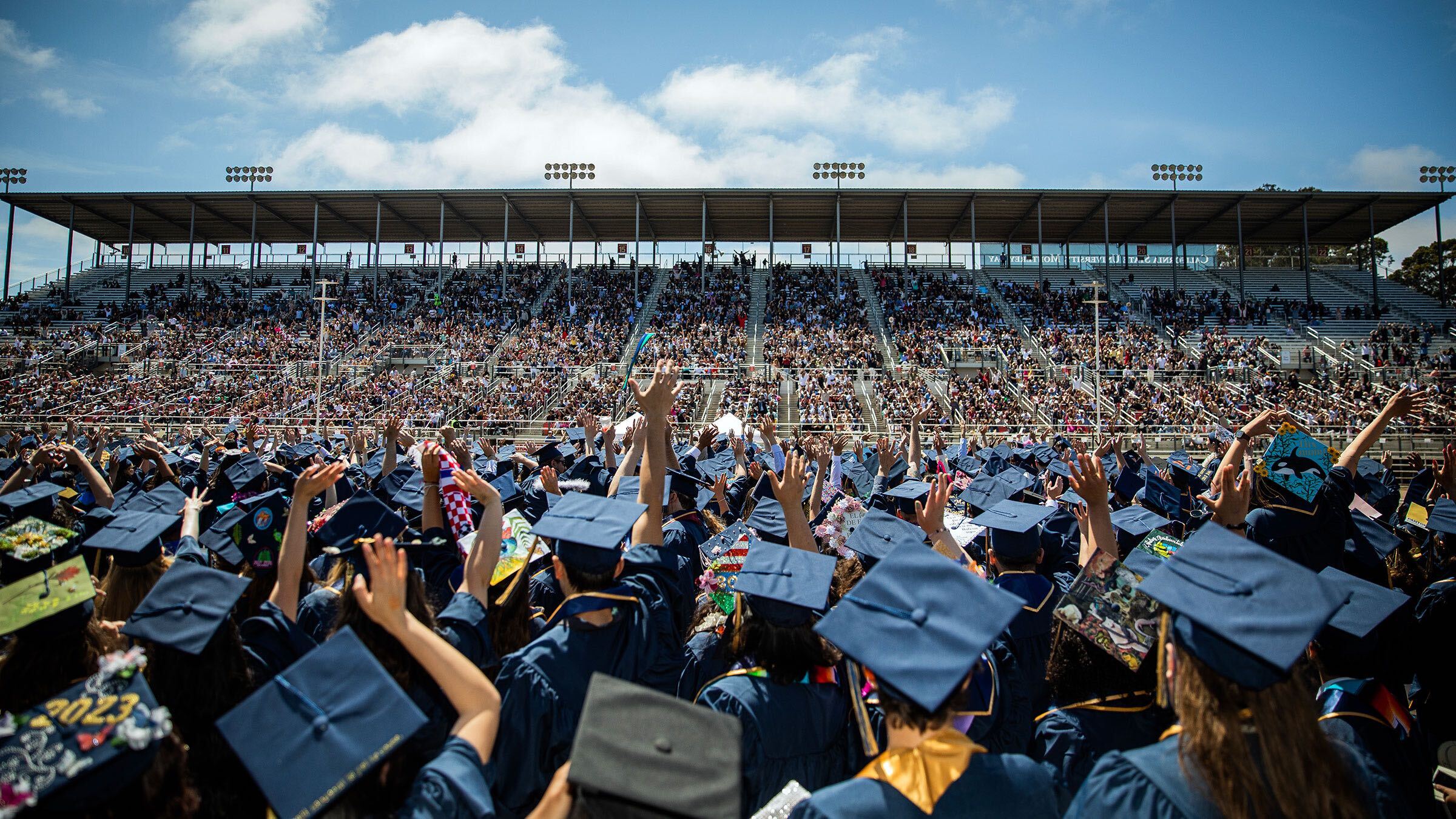 Graduating students wave to their families during the 2023 Commencement at the Salinas Sports Complex. | Photo by Brent Dundore-Arias