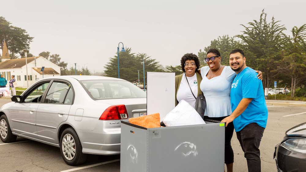 Welcome team and parent helping a student on Move-in day