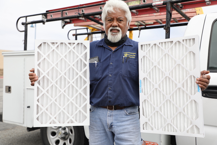 Augie Eclarin, from Facilities, holding a MERV 8 (left) and MERV 13 filters