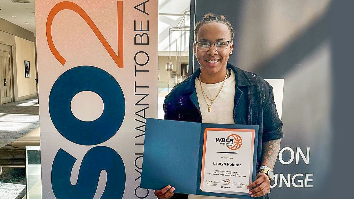 Basketball player holding WBCA certificate